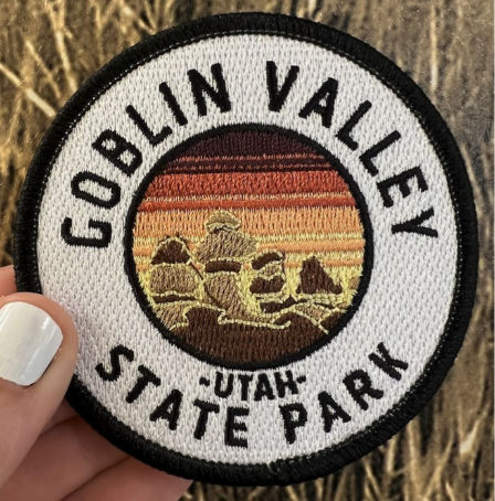 Embroidered circular Goblin Valley State Park Utah souvenir patch with hoodoo rock formations and sunset stripes.