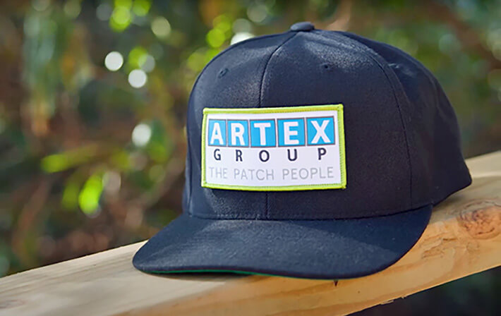 Black cap with custom embroidered patch by Artex Group - The Patch People, showcasing brand logo on a stylish, high-quality patch for hats.